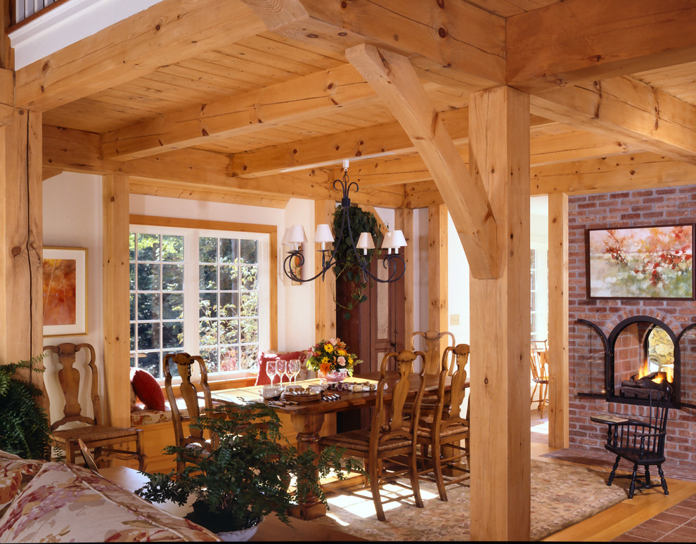 Esempio di una sala da pranzo aperta verso la cucina chic con parquet chiaro, camino bifacciale, cornice del camino in mattoni e pareti beige