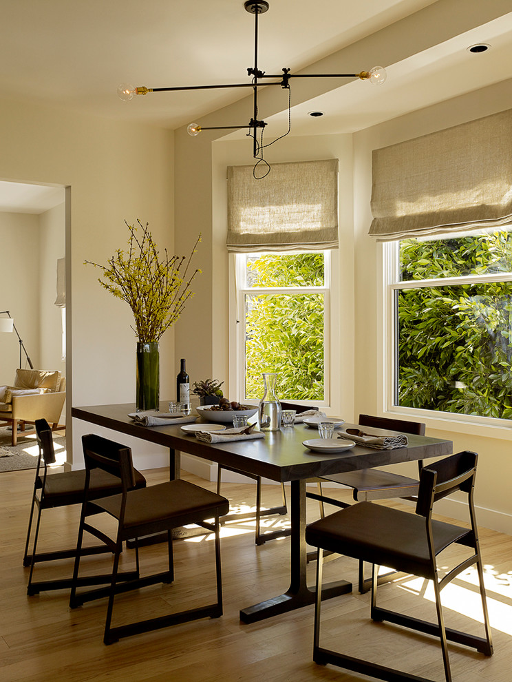 Idée de décoration pour une salle à manger design avec un mur beige et un sol en bois brun.