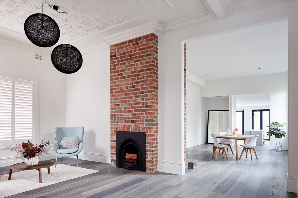 Offenes, Mittelgroßes Modernes Esszimmer mit weißer Wandfarbe, braunem Holzboden, Kamin, Kaminumrandung aus Backstein und grauem Boden in Melbourne