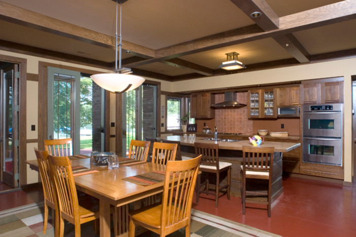 Idée de décoration pour une salle à manger ouverte sur le salon craftsman avec un mur beige, sol en béton ciré et éclairage.