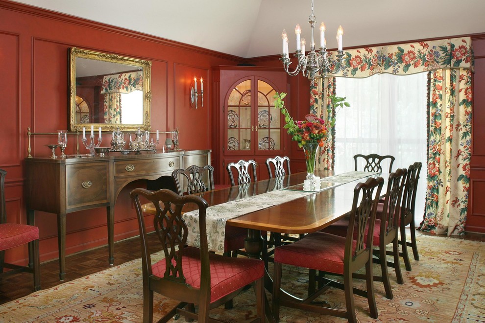 Example of a large classic dark wood floor enclosed dining room design in Kansas City with red walls and no fireplace