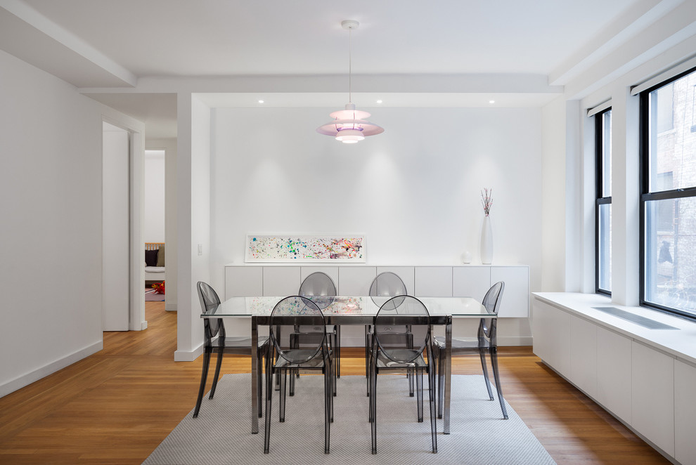 Foto di una sala da pranzo contemporanea di medie dimensioni con pareti bianche, nessun camino e pavimento in legno massello medio