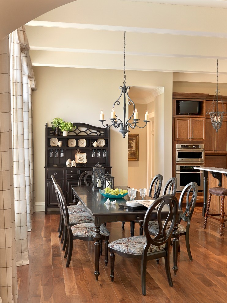 Idee per una sala da pranzo aperta verso la cucina classica con pareti beige, parquet scuro e pavimento marrone