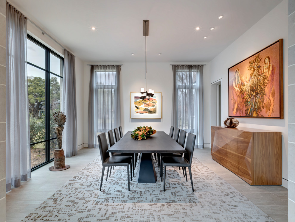 Contemporary dining room in Dallas with white walls and grey floors.