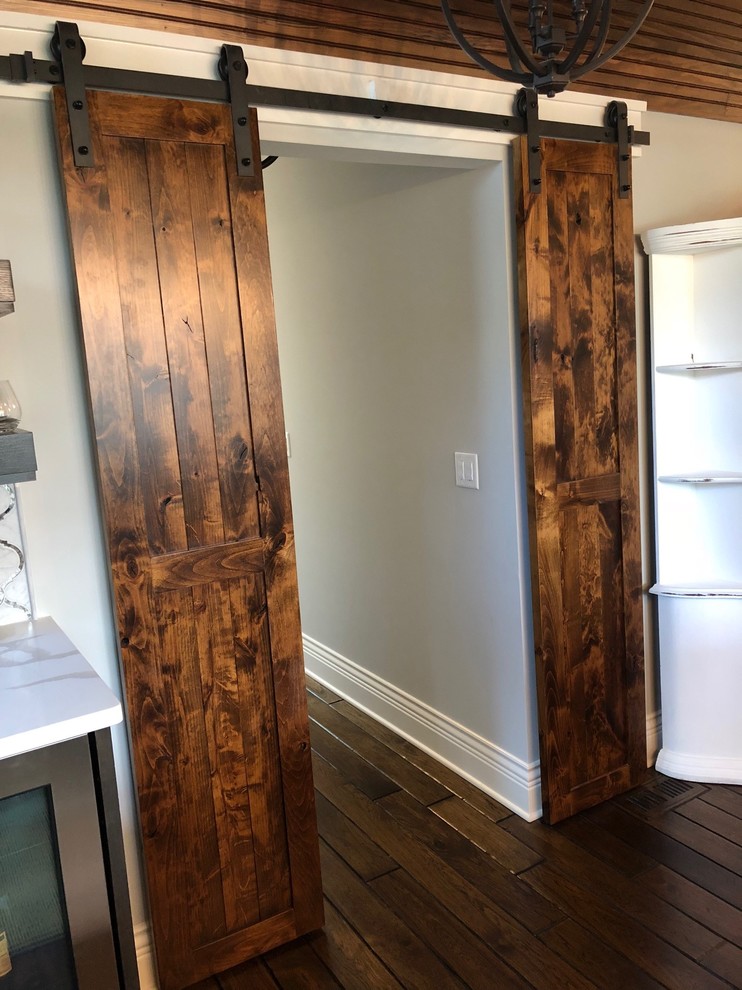 Modelo de comedor de estilo de casa de campo de tamaño medio cerrado con paredes grises, suelo de madera oscura y suelo marrón