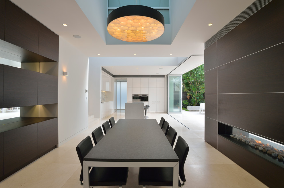 Mid-sized minimalist limestone floor dining room photo in Sydney with white walls, a two-sided fireplace and a wood fireplace surround