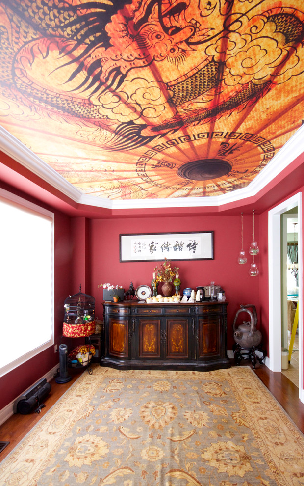 Foto di una sala da pranzo etnica chiusa e di medie dimensioni con pareti rosse e pavimento in legno massello medio