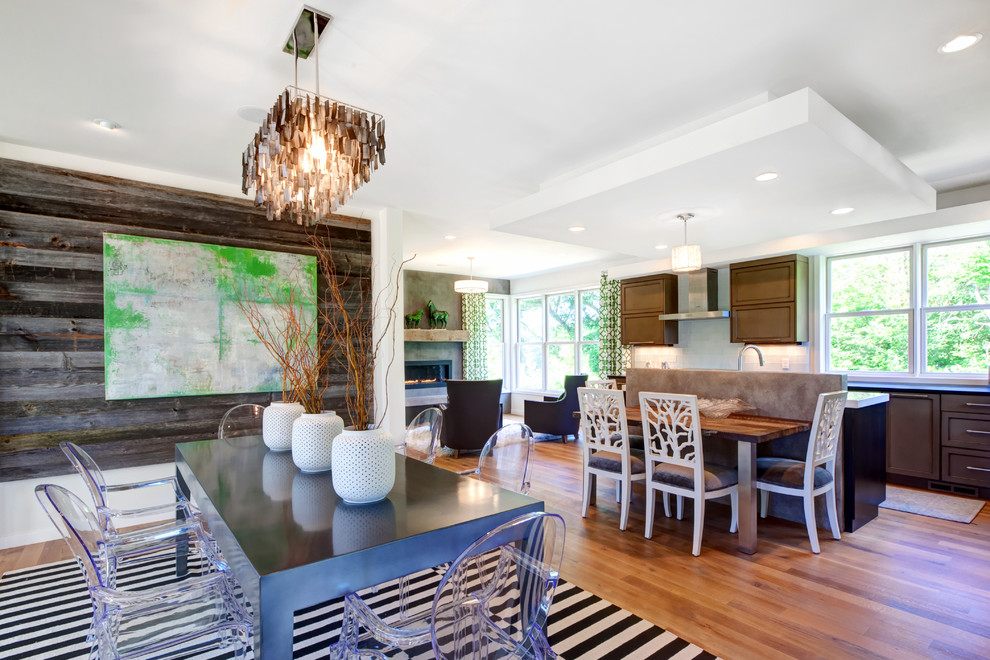 Foto di una sala da pranzo aperta verso la cucina minimal con pareti bianche e pavimento in legno massello medio