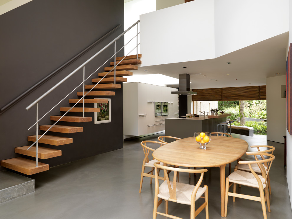 Inspiration pour une salle à manger ouverte sur la cuisine design avec un mur multicolore et sol en béton ciré.