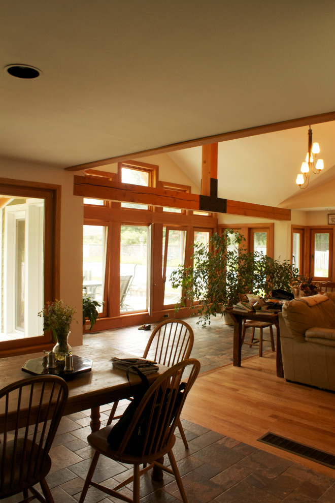 Inspiration pour une salle à manger design avec une banquette d'angle, un mur blanc, un sol en ardoise, un sol marron et un plafond voûté.