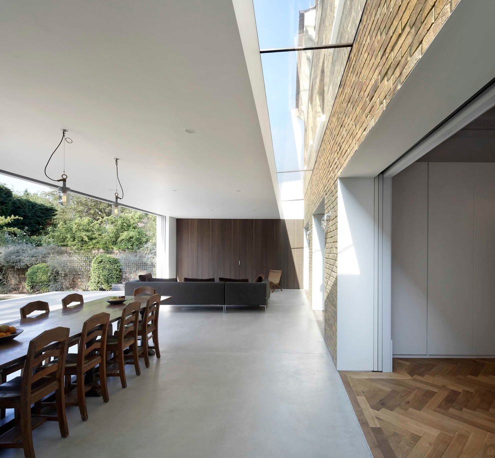 Inspiration for a modern dining room in London with concrete flooring.