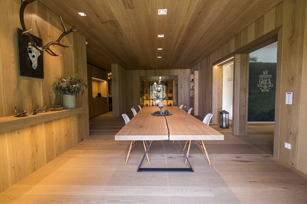 Cette photo montre une salle à manger ouverte sur le salon montagne avec un mur marron, parquet clair et un sol marron.