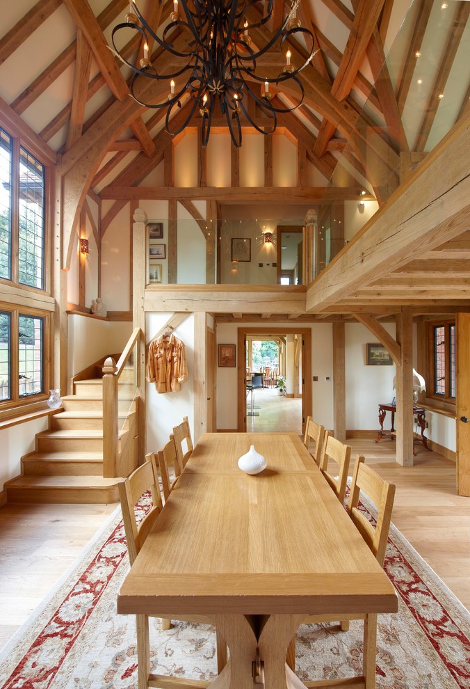 Cette photo montre une salle à manger chic avec un mur blanc et un sol en bois brun.