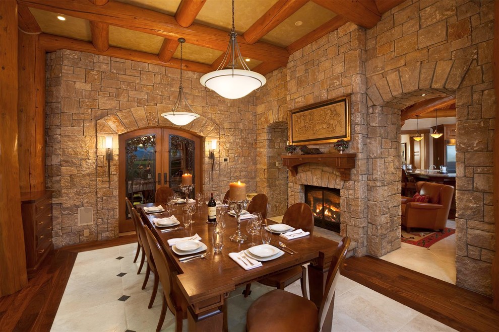 Aménagement d'une salle à manger montagne fermée avec une cheminée standard, un manteau de cheminée en pierre et parquet foncé.