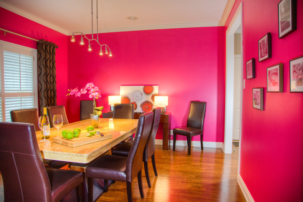 Immagine di una sala da pranzo design chiusa e di medie dimensioni con pareti rosa e parquet chiaro