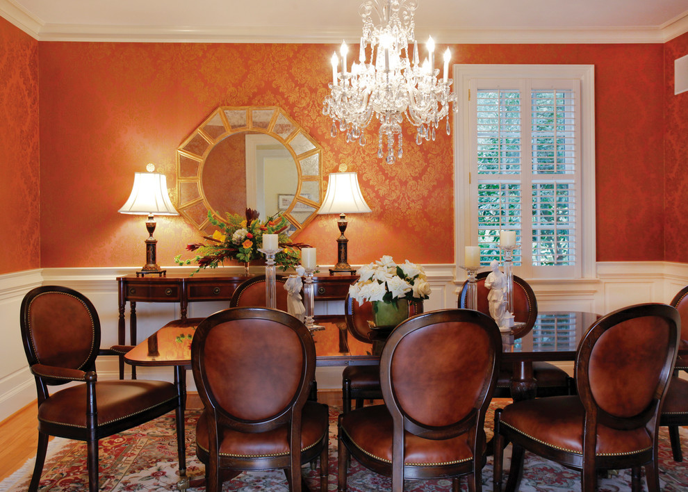 Inspiration pour une salle à manger traditionnelle avec un mur rouge et un sol en bois brun.
