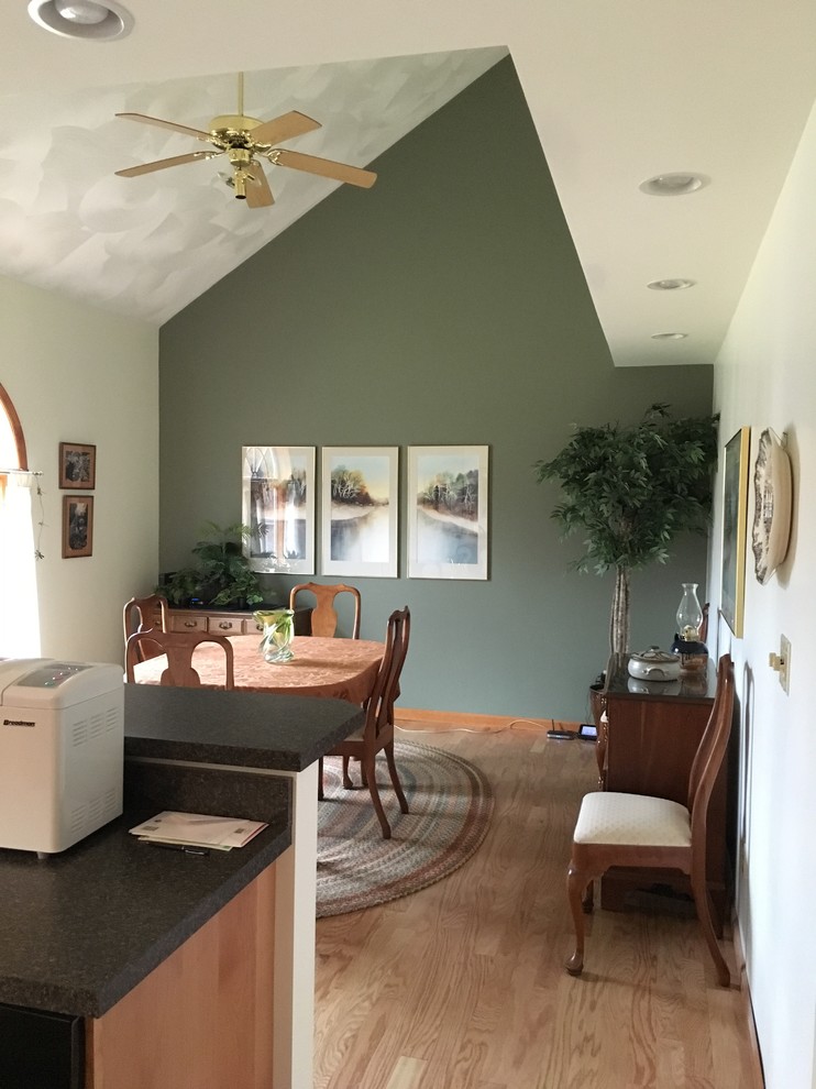 Пример оригинального дизайна: кухня-столовая среднего размера в стиле неоклассика (современная классика) с зелеными стенами, светлым паркетным полом и коричневым полом без камина