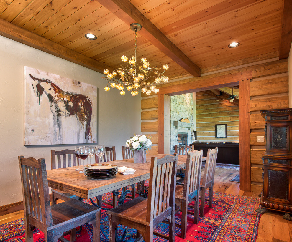 Cette photo montre une salle à manger montagne fermée avec un mur gris et un sol en bois brun.