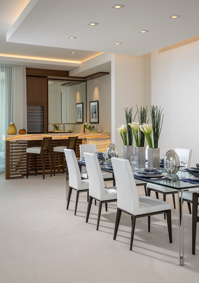 Immagine di una grande sala da pranzo aperta verso il soggiorno costiera con pareti bianche, pavimento in pietra calcarea e pavimento beige
