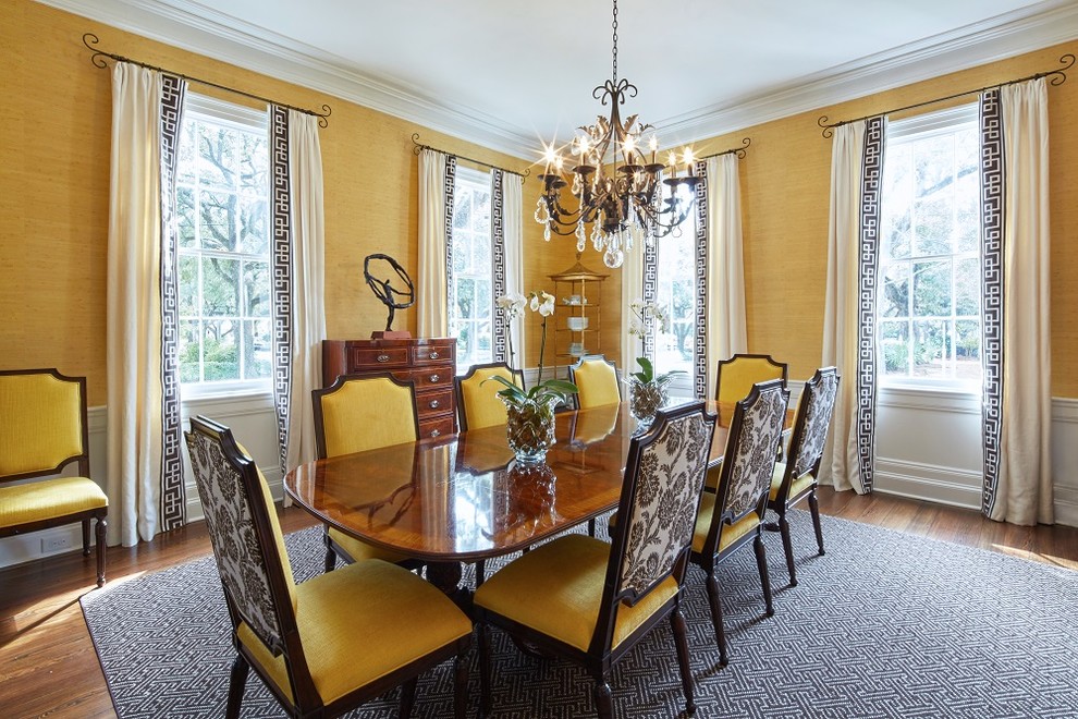 Photo of a large classic dining room in Charleston with yellow walls, medium hardwood flooring and a standard fireplace.