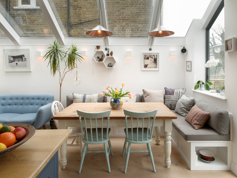 Große Klassische Wohnküche mit hellem Holzboden, weißer Wandfarbe und beigem Boden in London