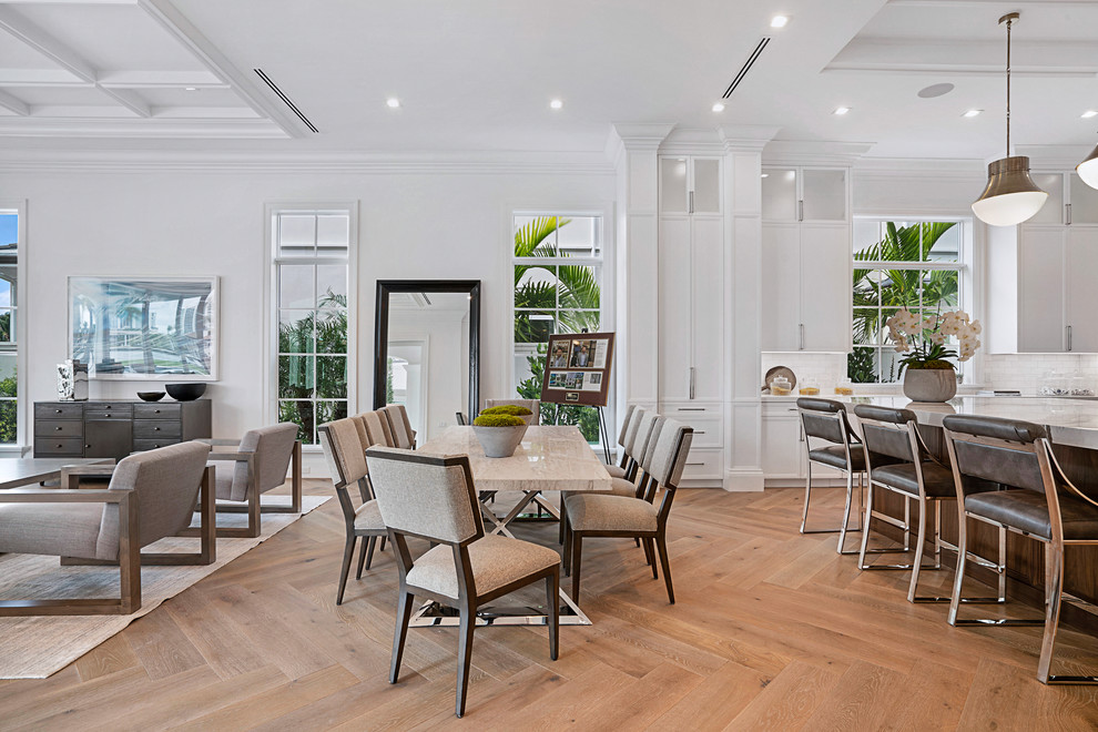 This is an example of a classic open plan dining room in Miami with white walls, medium hardwood flooring and brown floors.