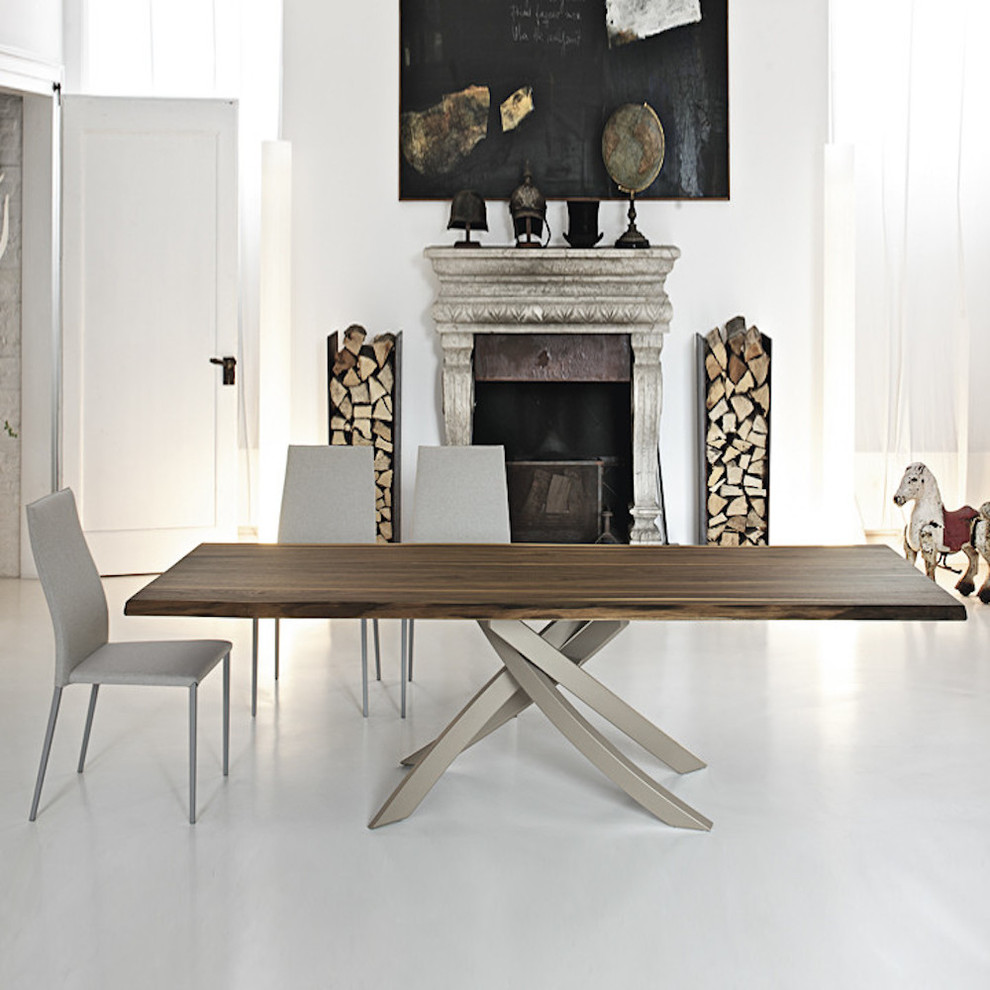 Réalisation d'une grande salle à manger ouverte sur le salon minimaliste avec un mur blanc, sol en béton ciré, une cheminée standard, un manteau de cheminée en pierre et un sol blanc.