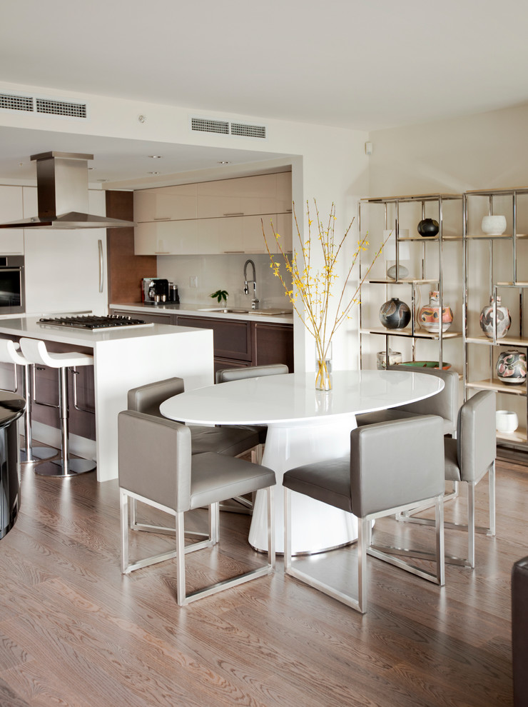 На фото: кухня-столовая в современном стиле с белыми стенами и паркетным полом среднего тона