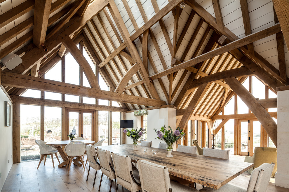 Farmhouse dining room in Gloucestershire with white walls, medium hardwood flooring and brown floors.