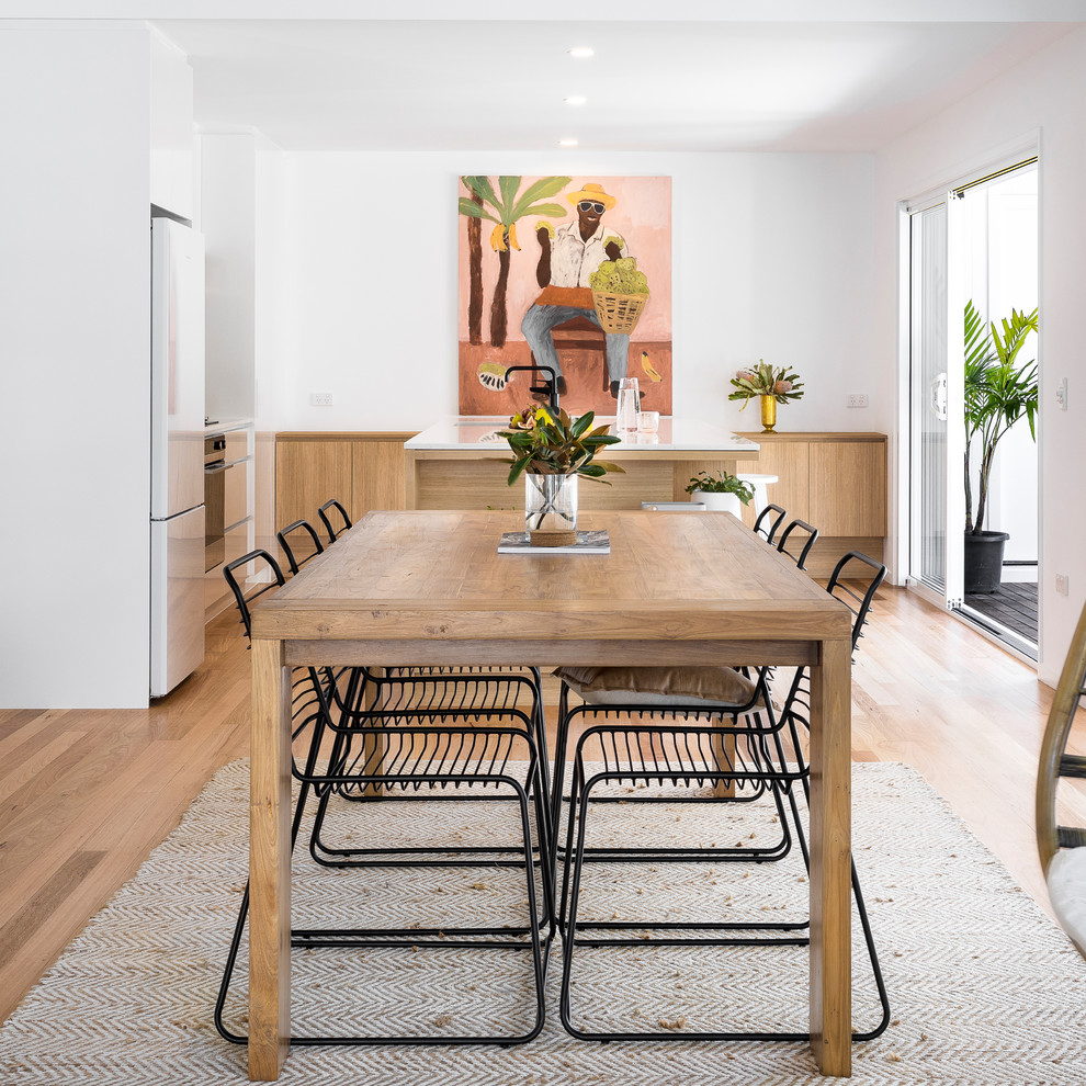 Esempio di una sala da pranzo aperta verso il soggiorno minimal di medie dimensioni con pareti bianche, pavimento in legno massello medio e pavimento marrone