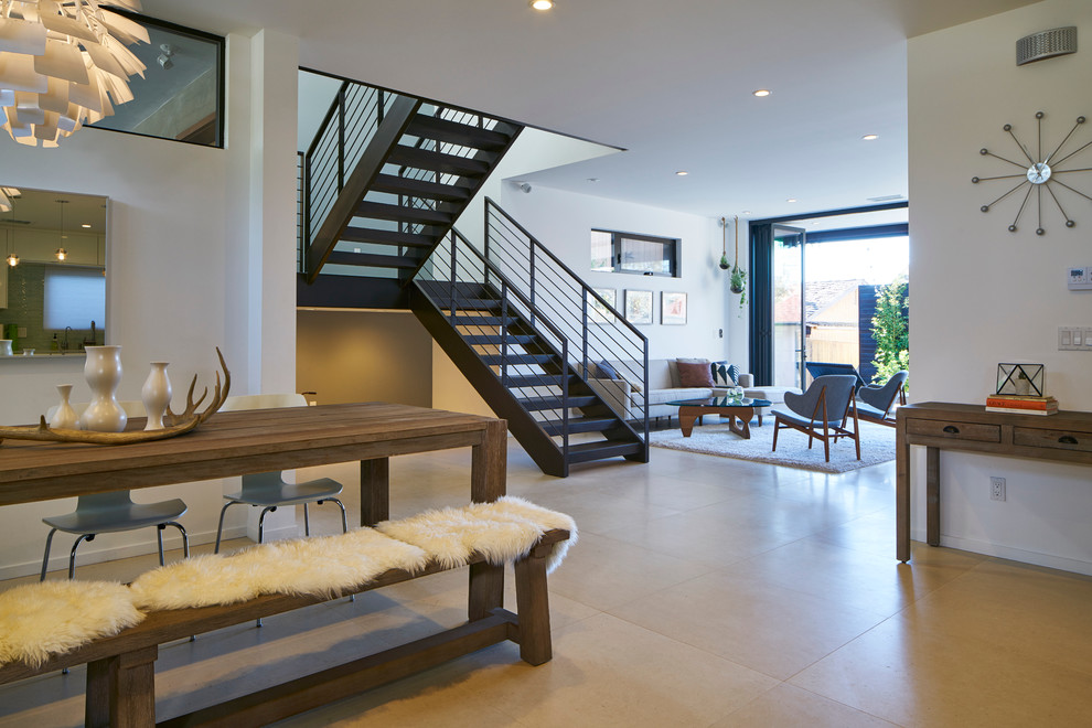На фото: большая гостиная-столовая в стиле модернизм с белыми стенами и полом из керамической плитки без камина с