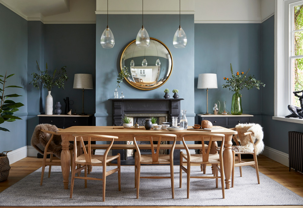 Свежая идея для дизайна: отдельная столовая в стиле неоклассика (современная классика) с синими стенами, паркетным полом среднего тона, стандартным камином и коричневым полом - отличное фото интерьера