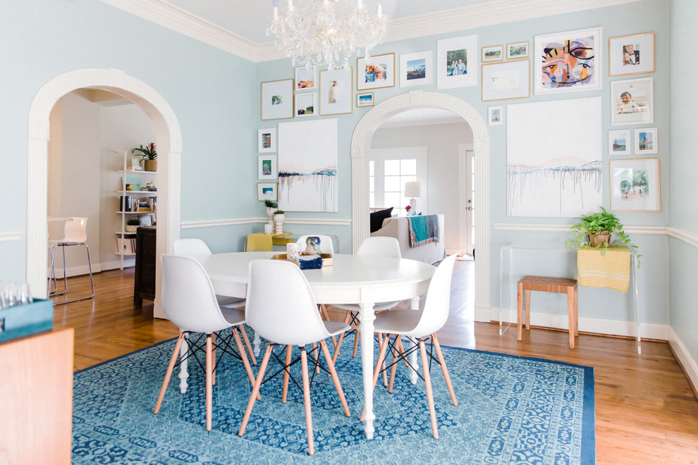 Idées déco pour une salle à manger classique avec un mur bleu et un sol marron.