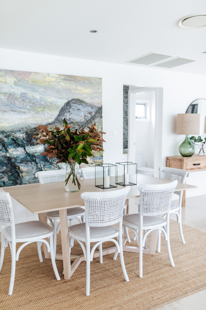 Inspiration pour une salle à manger ouverte sur le salon marine avec un mur blanc et un sol gris.