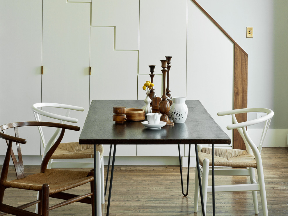 Modern dining room in New York with grey walls and dark hardwood flooring.