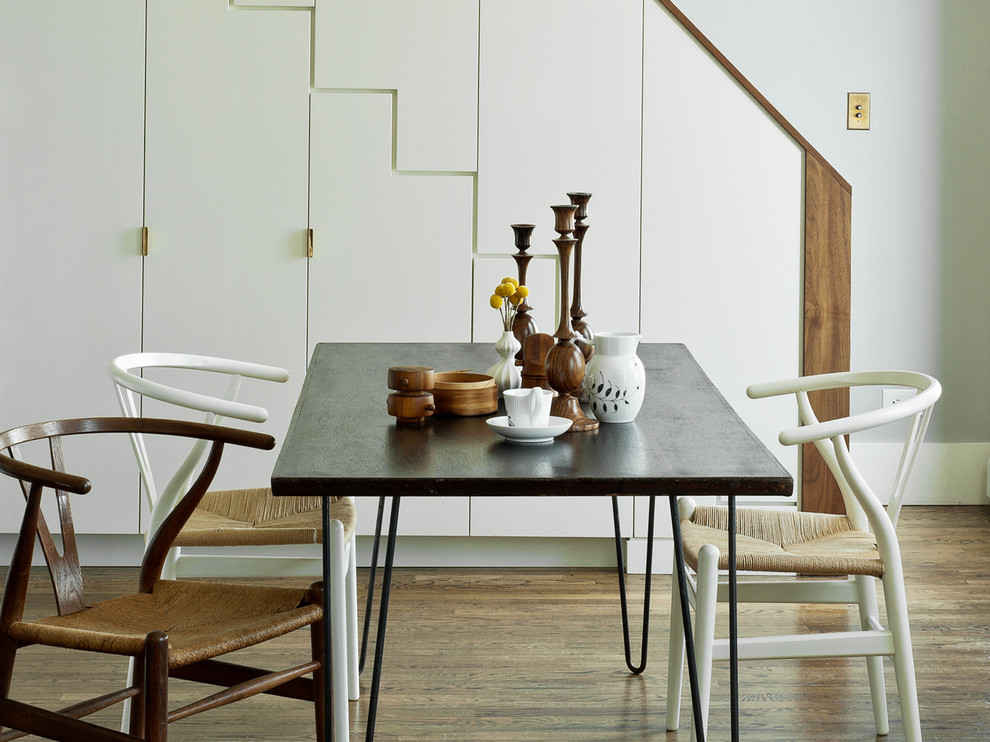 Modelo de comedor minimalista con paredes grises y suelo de madera oscura