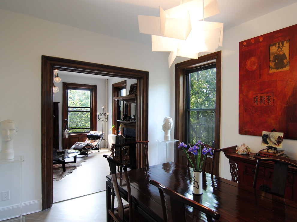 Inspiration pour une salle à manger ouverte sur la cuisine bohème de taille moyenne avec un mur blanc et un sol en bois brun.