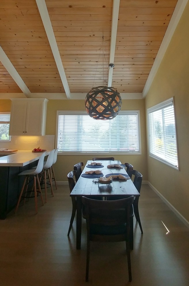 Idee per una sala da pranzo aperta verso la cucina design di medie dimensioni con pareti gialle e pavimento in legno massello medio