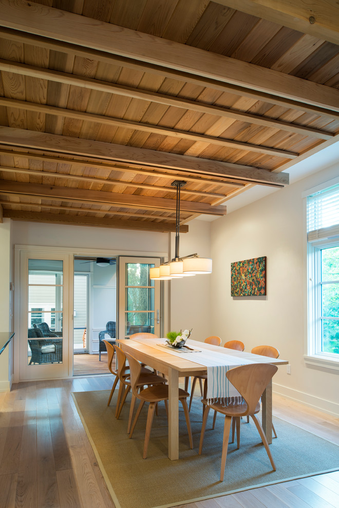 Imagen de comedor contemporáneo con paredes blancas y suelo de madera clara
