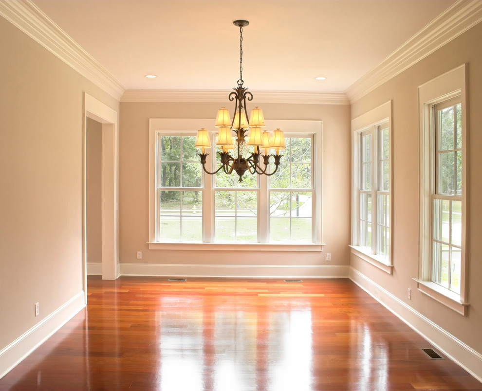 Inspiration for a large timeless medium tone wood floor enclosed dining room remodel in Minneapolis with beige walls