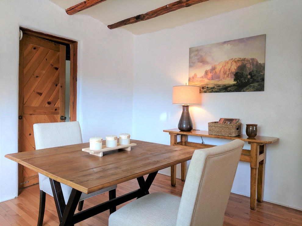 Foto de comedor de estilo americano pequeño cerrado sin chimenea con paredes blancas, suelo de madera en tonos medios y suelo marrón