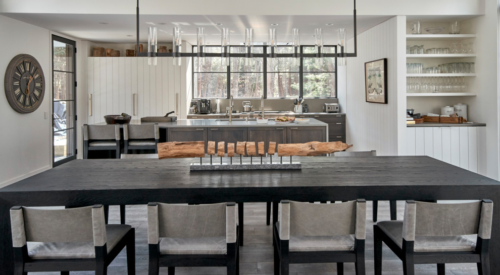Inspiration pour une salle à manger ouverte sur le salon rustique de taille moyenne avec un mur blanc, parquet clair, un sol gris et du lambris de bois.
