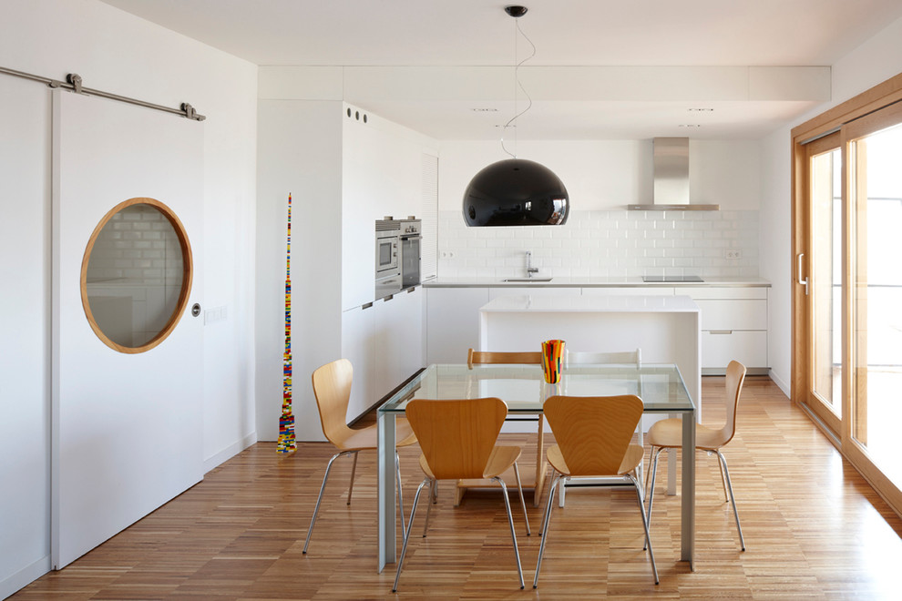 Aménagement d'une salle à manger ouverte sur la cuisine contemporaine de taille moyenne avec un mur blanc, parquet clair et aucune cheminée.