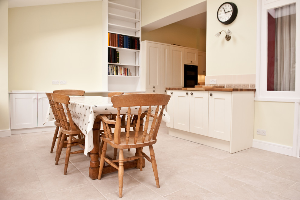 Immagine di una grande sala da pranzo aperta verso la cucina minimalista con pareti gialle e pavimento con piastrelle in ceramica