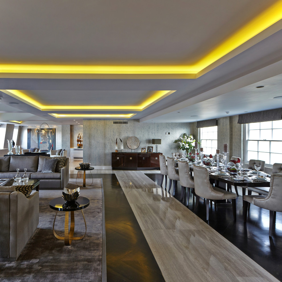 Cette image montre une salle à manger ouverte sur le salon design avec un mur gris et parquet foncé.