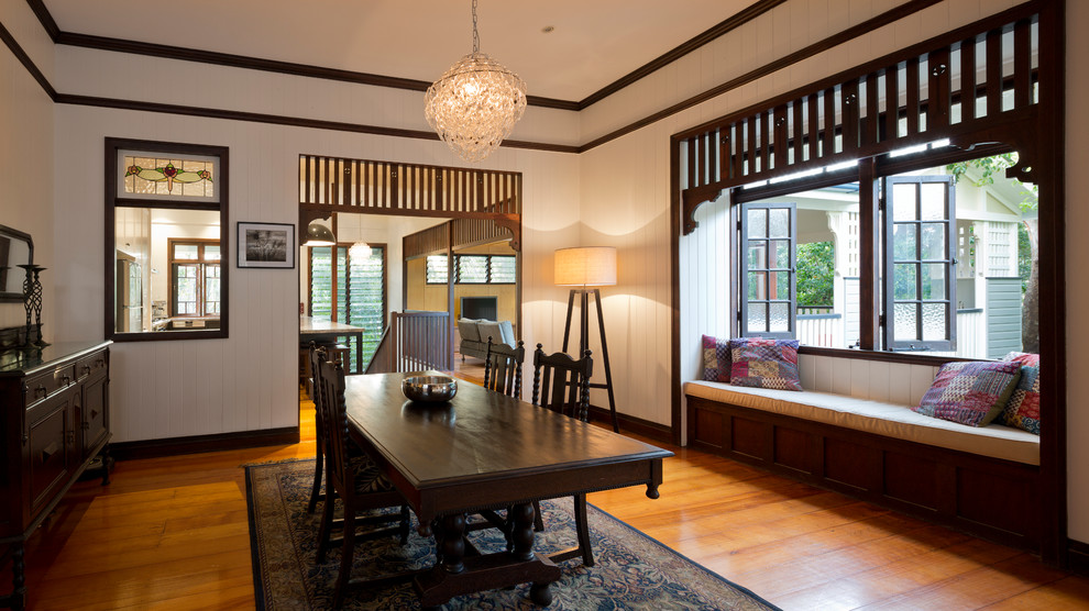 Réalisation d'une salle à manger ouverte sur le salon tradition de taille moyenne avec un mur blanc et un sol en bois brun.
