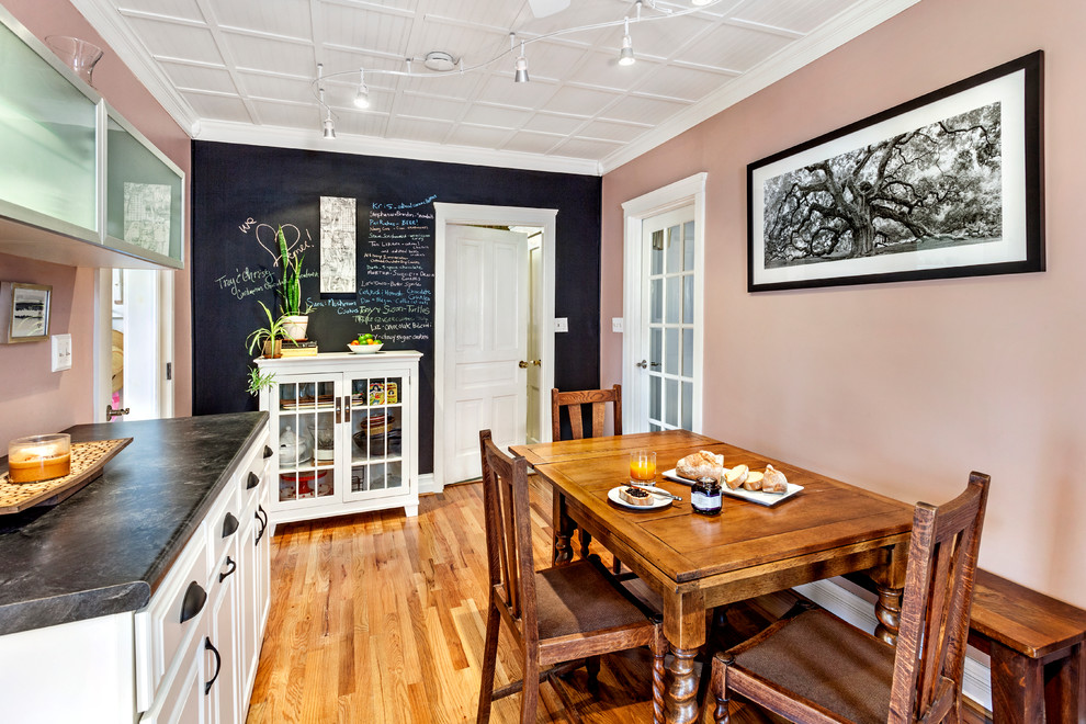 Idée de décoration pour une salle à manger ouverte sur la cuisine tradition avec un mur rose.