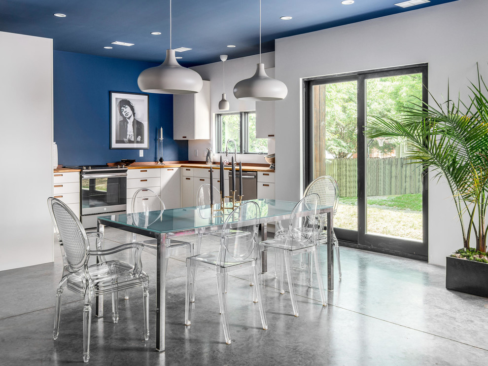 Idée de décoration pour une salle à manger ouverte sur le salon urbaine de taille moyenne avec un mur bleu, sol en béton ciré et un sol gris.