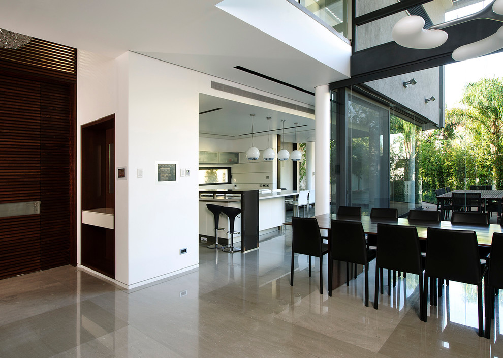 Immagine di una sala da pranzo aperta verso il soggiorno contemporanea con pareti bianche e pavimento in marmo
