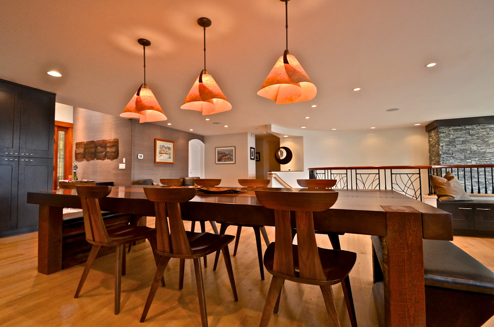 Foto di una sala da pranzo aperta verso il soggiorno design di medie dimensioni con pavimento in legno massello medio, pareti beige e nessun camino